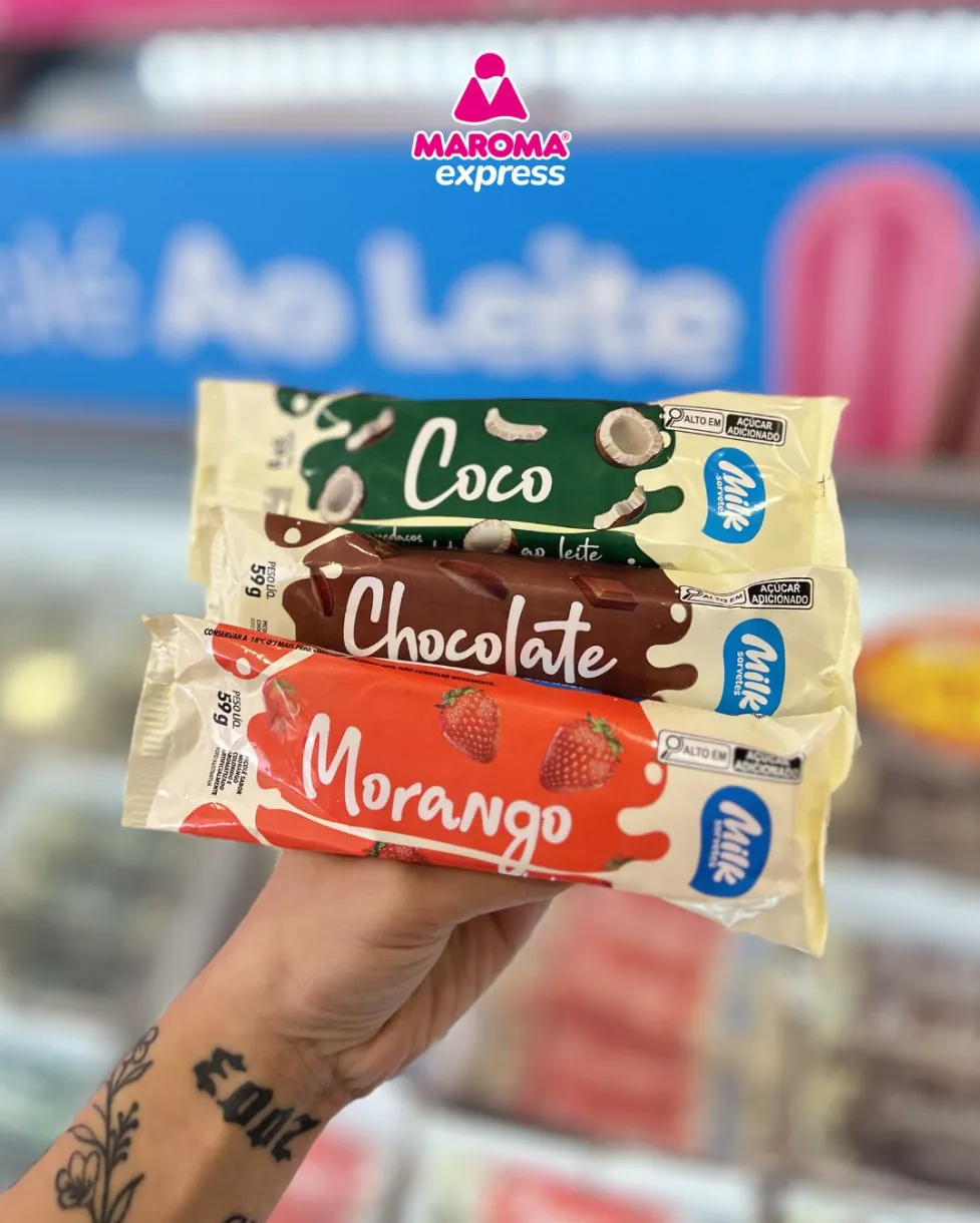 Três picolés ao leite Maroma nos sabores coco, chocolate e morango segurados na mão